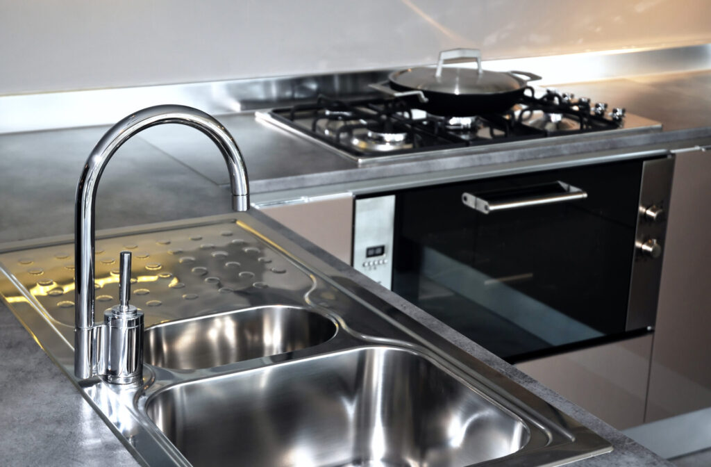 Water tap and sink › 스타일리쉬 플레이스 고급스러운 스테인리스 스틸 싱크대와 주방 내부, 깨끗하게 관리된 현대적인 주방 공간