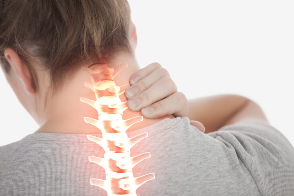 Digital composite of Highlighted spine of woman with neck pain › 스타일리쉬 플레이스 목 부위에 손을 대고 있는 사람의 뒷모습. 목 통증과 척추 건강의 중요성을 강조하는 장면.