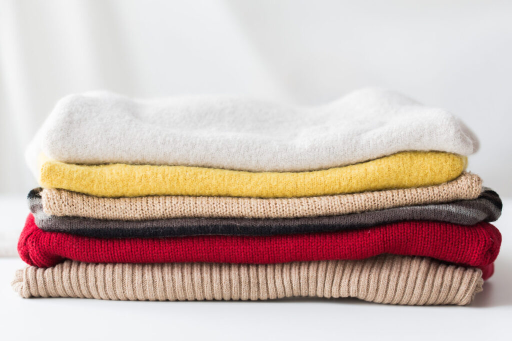 close up of stacked knitted clothes › 스타일리쉬 플레이스 다양한 색상의 니트가 깔끔하게 접혀 쌓여 있는 모습