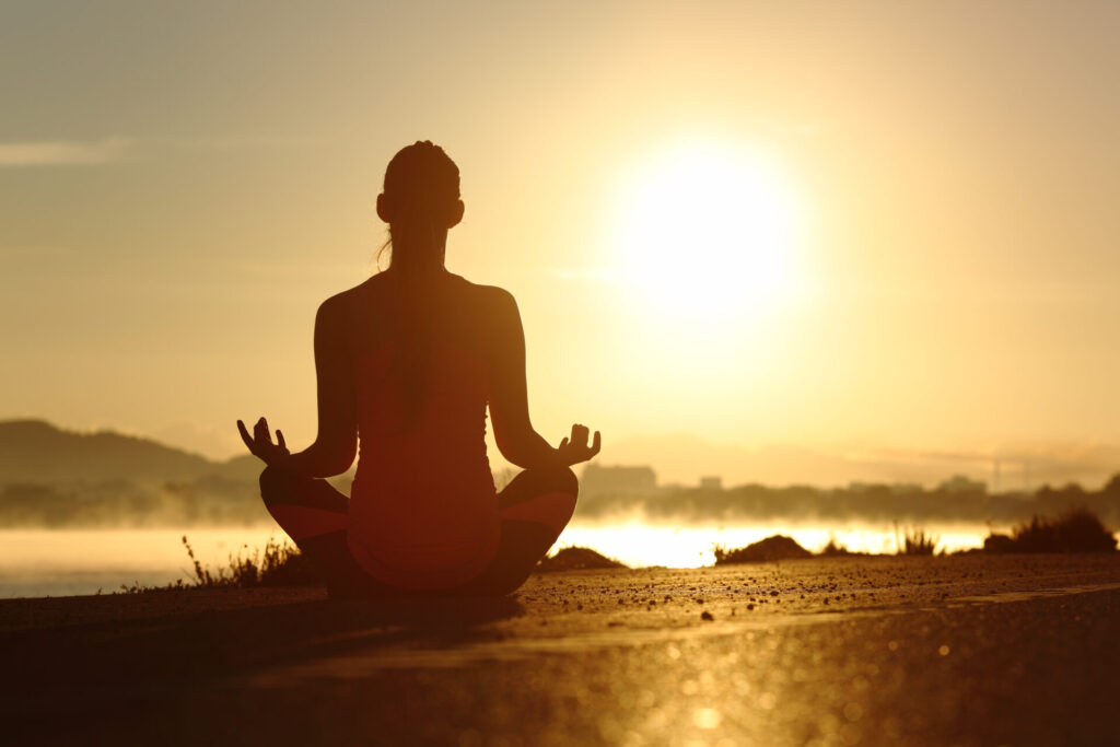 Silhouette of a fitness woman exercising yoga meditation exercises › 스타일리쉬 플레이스 일출을 배경으로 명상하는 여성, 자연 속에서 요가와 명상을 통해 마음의 평화를 찾는 장면
