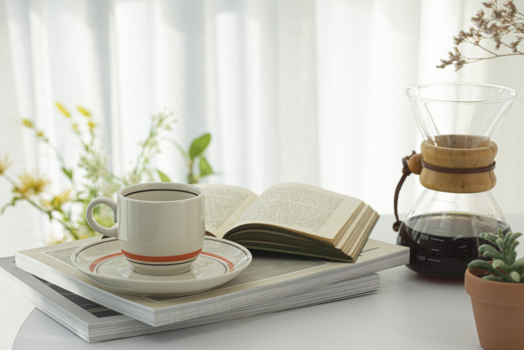 Home cafe with filter drip coffee and coffee cup › 스타일리쉬 플레이스 햇살이 비치는 창가에서 커피와 책이 놓인 아늑한 홈카페 공간