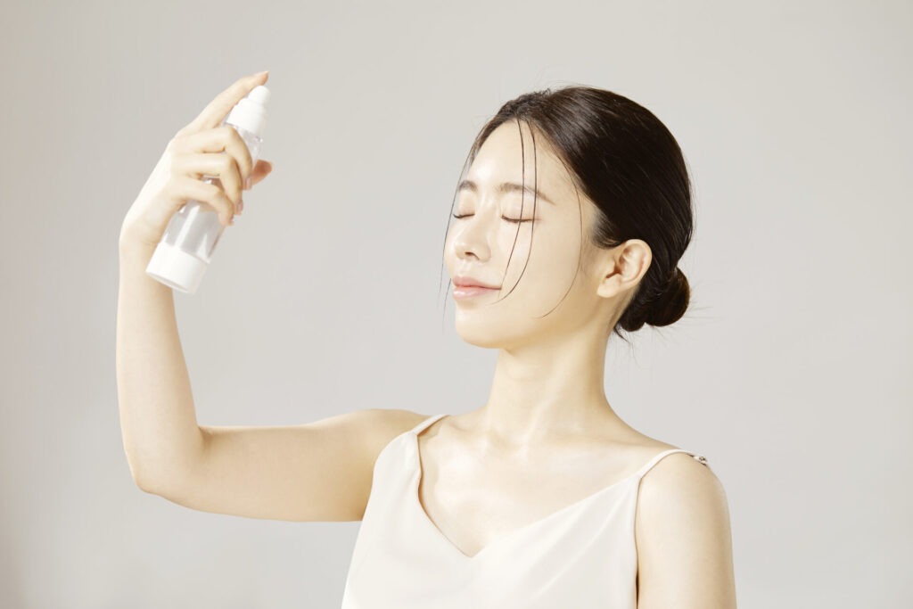 겨울철 촉촉한 피부 관리 › 스타일리쉬 플레이스 미스트를 얼굴에 뿌리며 보습 관리를 하는 여성의 모습