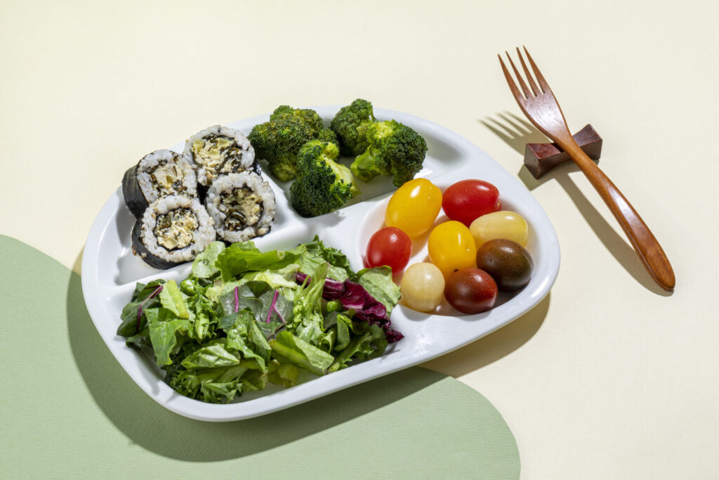 건강하고 영양가 높은 한 끼 식사 › 스타일리쉬 플레이스 샐러드, 김밥, 브로콜리, 방울토마토 등 건강한 식재료가 담긴 한 접시