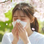 간절기, 벚꽃 아래에서 휴지를 들고 재채기하는 여성