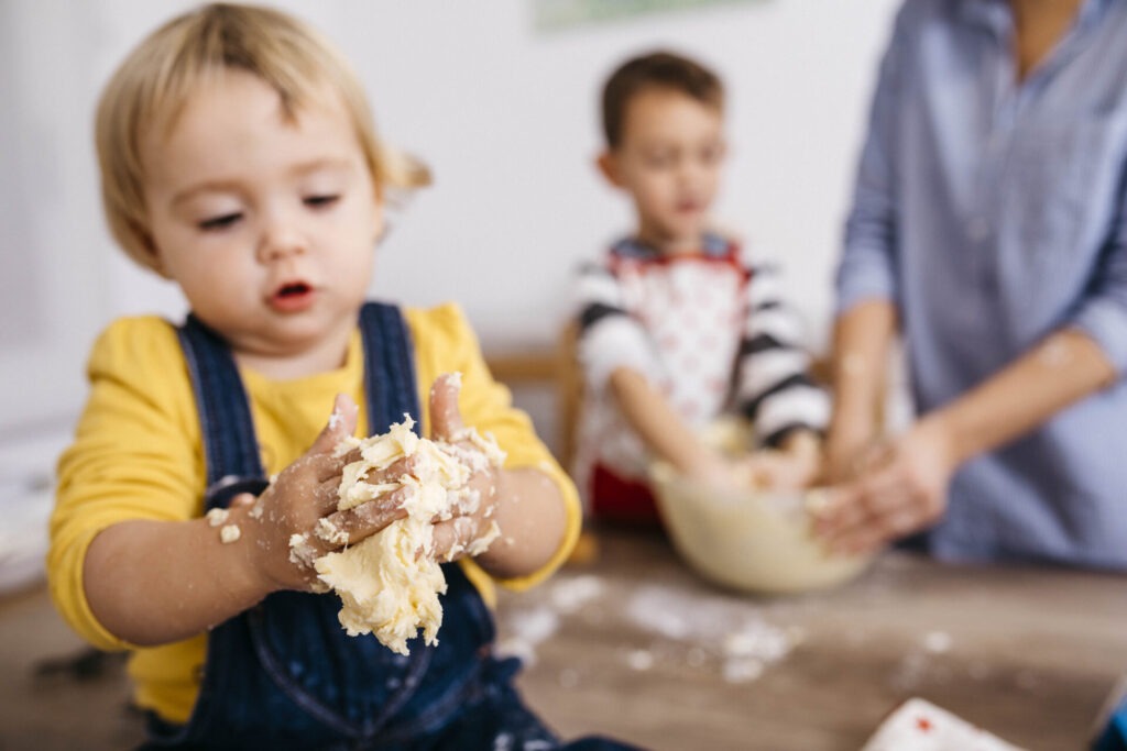 Toddler girl kneading dough with hers hands close-up › 스타일리쉬 플레이스 어린아이가 반죽을 손으로 만지며 베이킹을 체험하는 모습