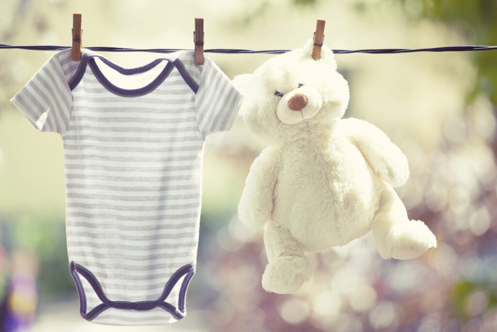 Baby clothes and teddy bear hanging on the clothesline › 스타일리쉬 플레이스 줄에 널린 아기 옷과 봉제 인형, 햇빛에 자연 건조되는 모습으로 친환경세탁과 유아용품 세탁을 연상