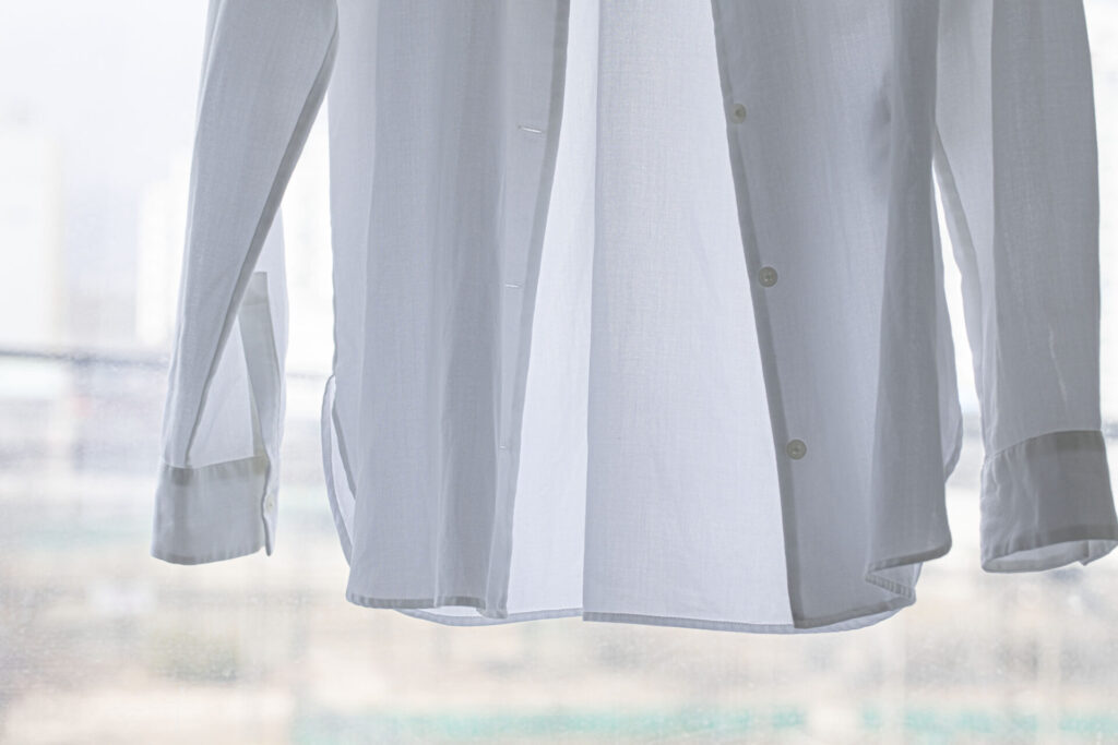 White shirt hanging to dry on clothes line › 스타일리쉬 플레이스 밝은 햇살 아래 자연 건조 중인 흰 셔츠, 친환경 세탁과 에너지 절약을 상징