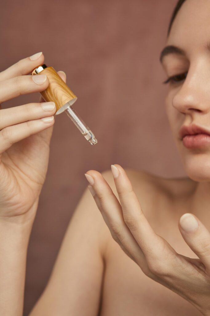 close up woman holding serum › 스타일리쉬 플레이스 피부에 세럼을 떨어뜨리는 여성의 손과 얼굴 클로즈업, 피부장벽 강화를 위한 스킨케어 장면