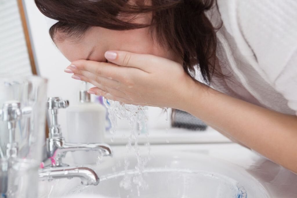 Close-up side view of woman washing face › 스타일리쉬 플레이스 세면대에서 미온수로 얼굴을 세정하고 있는 여성, 피부장벽 보호를 위한 클렌징 장면
