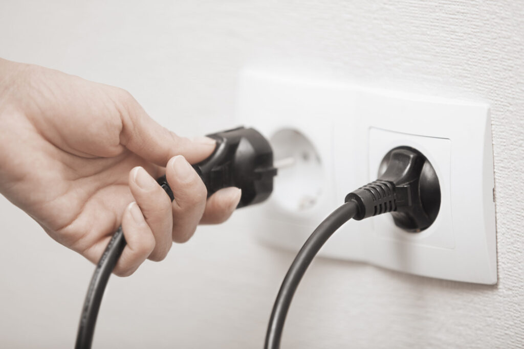 Electric plug › 스타일리쉬 플레이스 콘센트에서 전기 플러그를 손으로 빼는 모습, 대기전력 절감을 위한 실천 행동을 나타낸 이미지