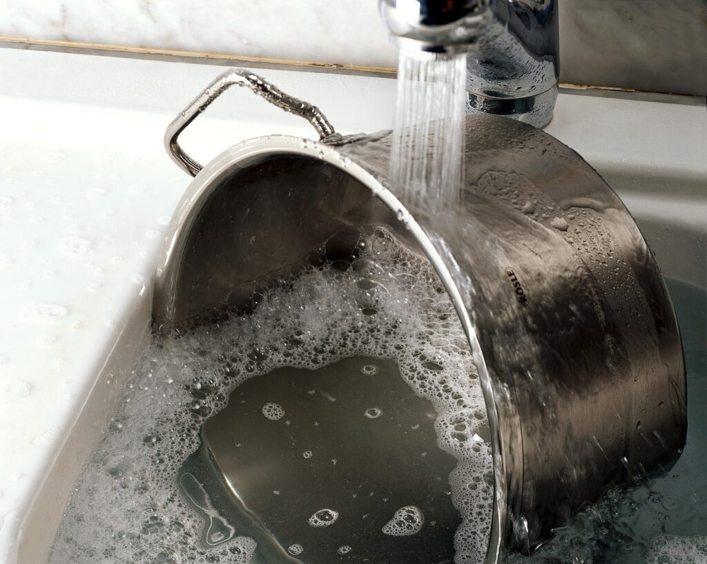 스테인리스 냄비를 물과 세제로 세척하는 과정, 냄비 탄 자국 제거법 실천 장면