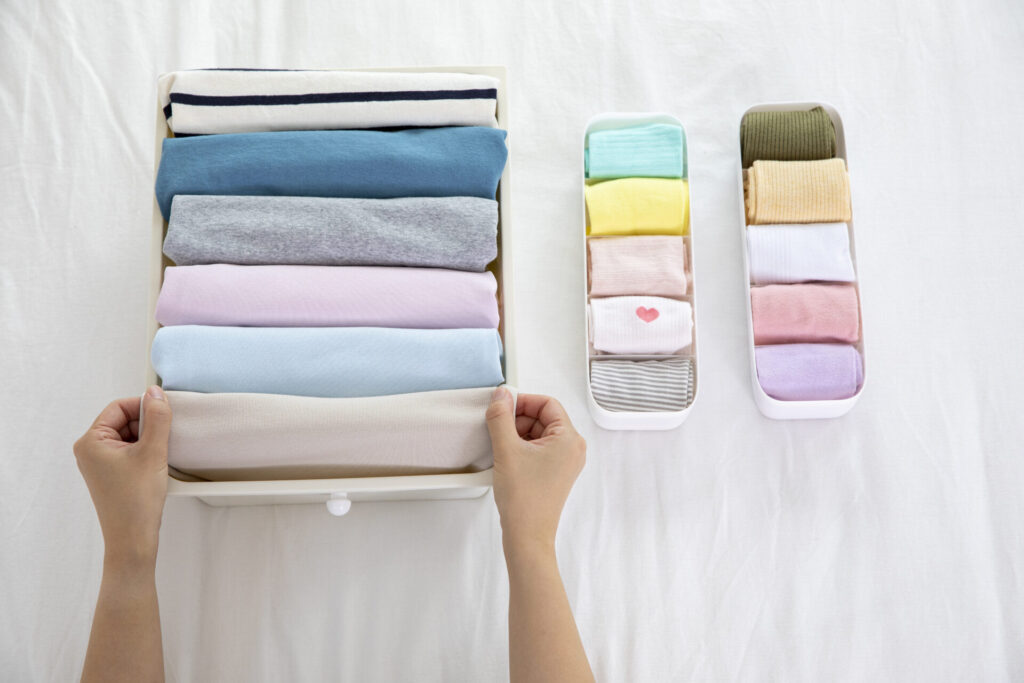 드레스룸에서 옷을 정리하며 수납하는 여성의 모습